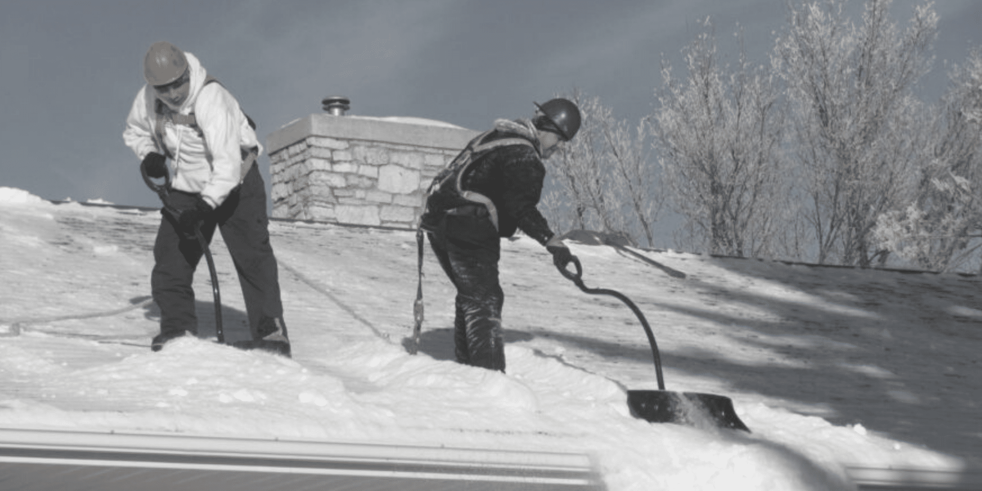 Couvreurs font un déneigement de toiture de maison